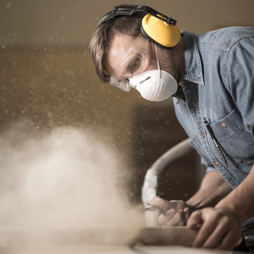 Carpenter,Wearing,Protective,Headphones,While,Using,Electric,Saw